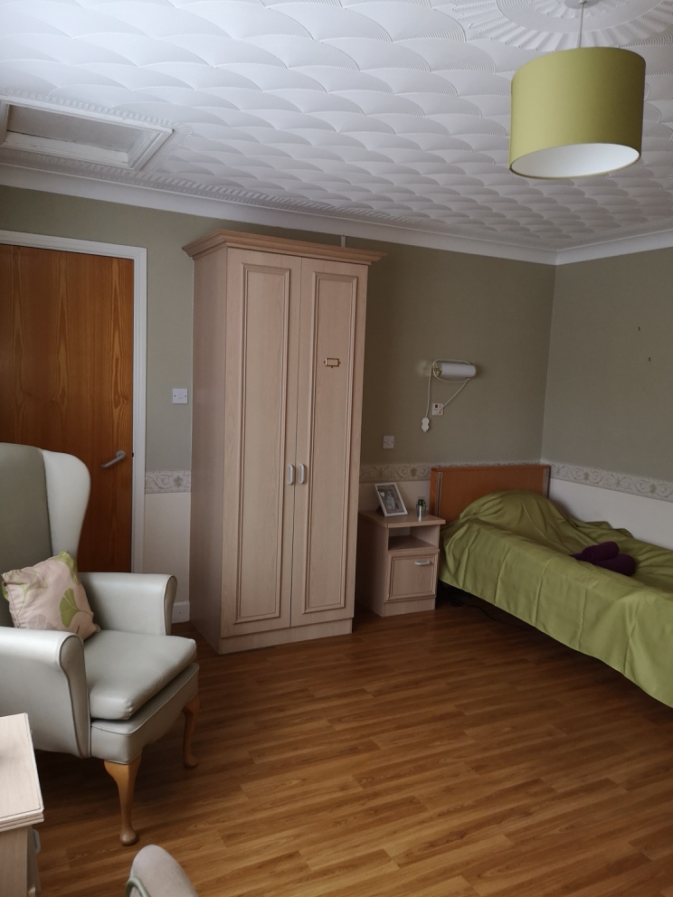 care home bedroom with green walls and decor